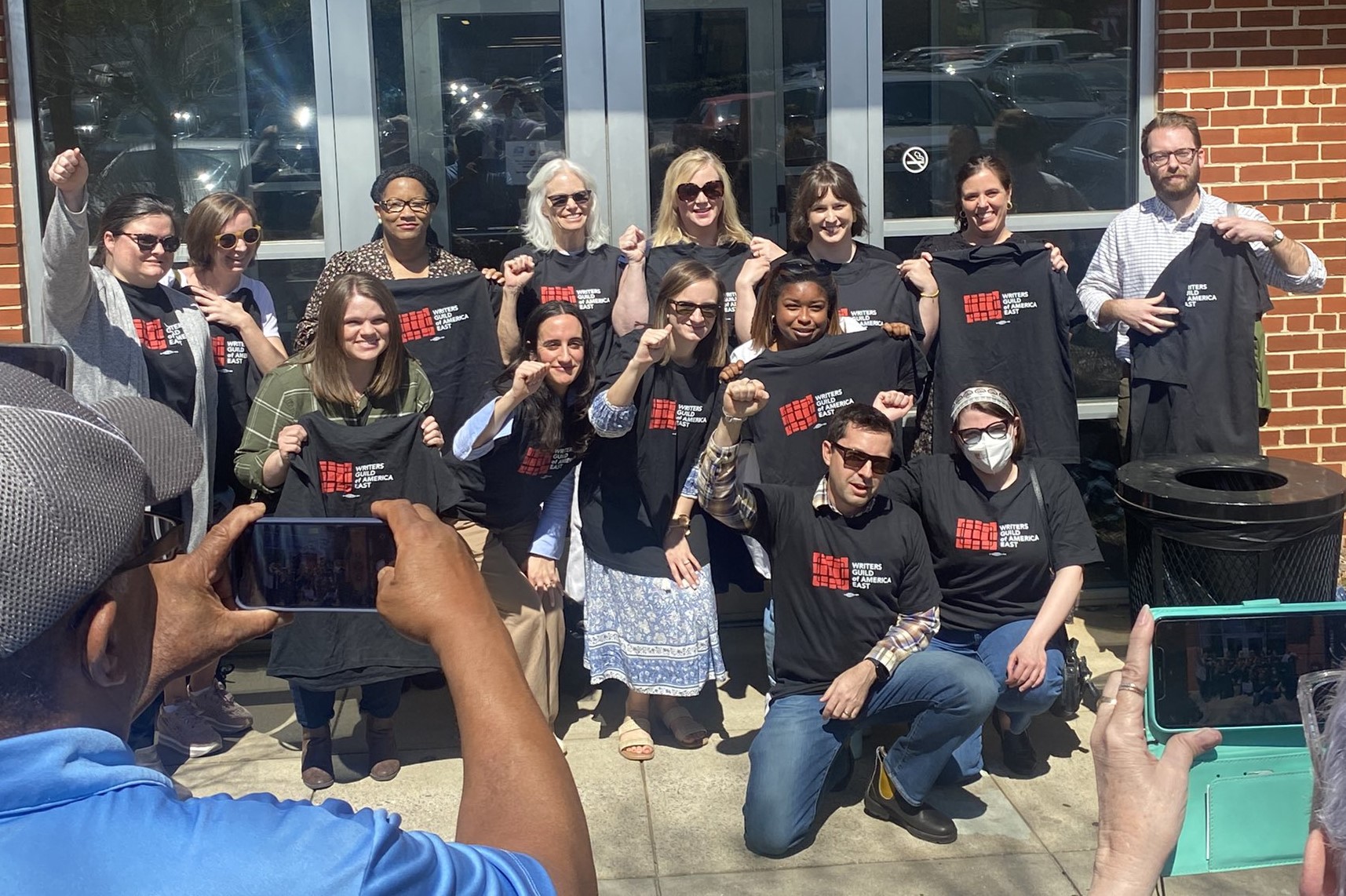 Hearst Union workers at Country Living and Veranda magazines pose for a picture on with Writers Guild of America, East T-shirts during their Thursday, March 23, 2023 walkout from their office at Birmingham's Pepper Place.