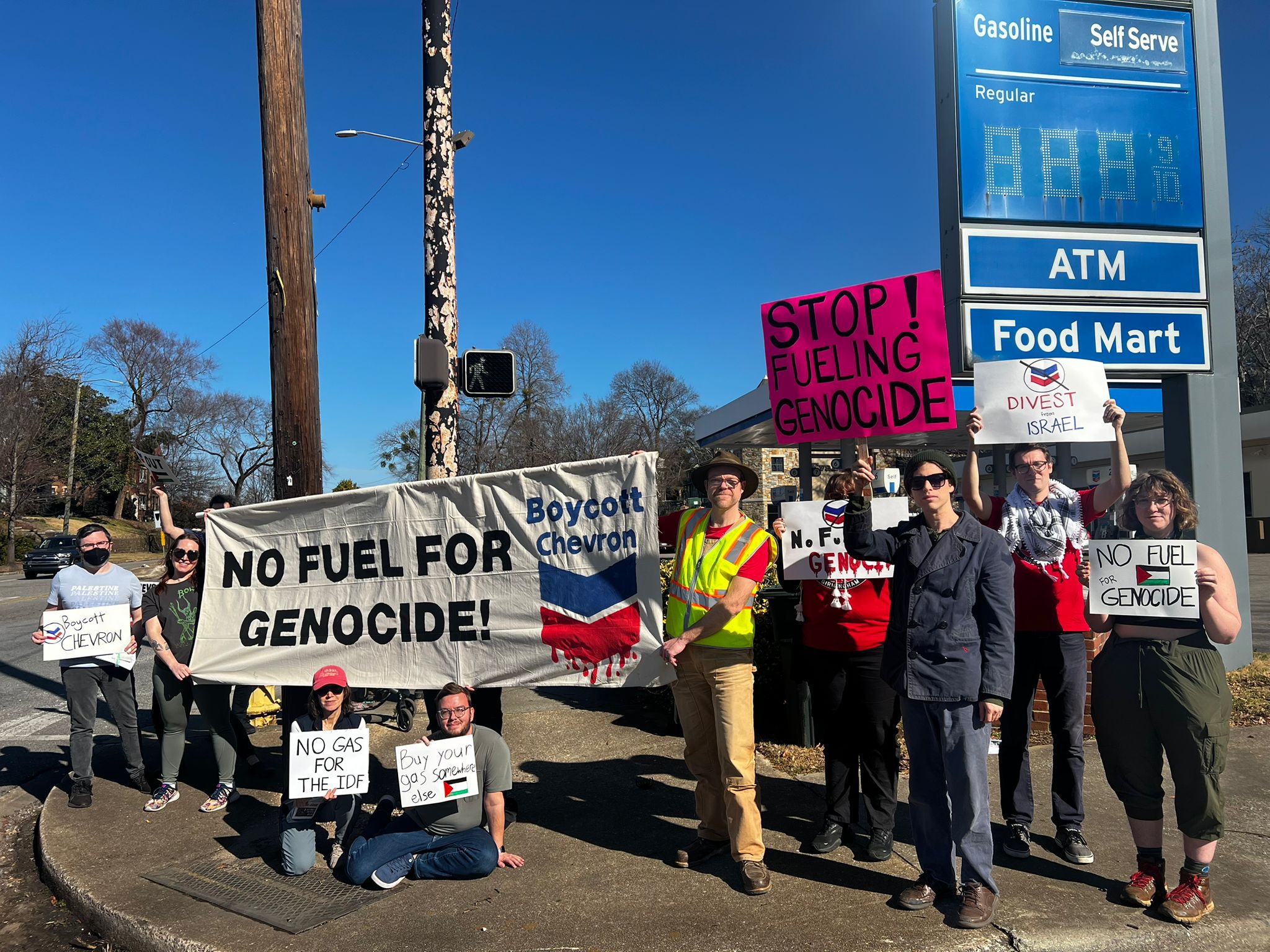 Birmingham DSA members hold signs and banners in front of the Chevron station on Clairmont Avenue in Birmingham. This is part of the chapter's 'Stop Fueling Genocide' campaign to pressure Chevron into ending their business with Israel -- and complicity with the genocide in Gaza.